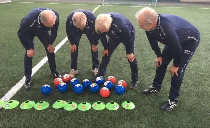 Foto av fire menn som ser på baller.