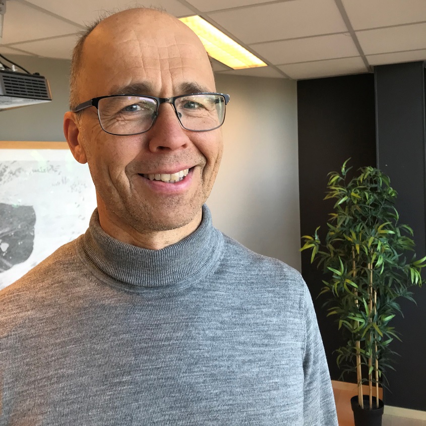 Foto av en smilende Henrik Carlsen.